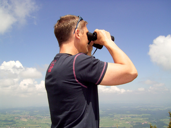 Foto Ludger mit Fernglas &uuml;ber Allg&auml;u-Berge blickend